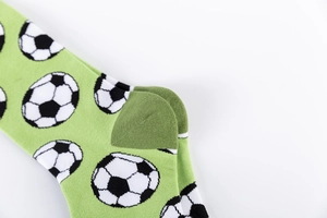 Close-up of reinforced heel and jacquard knit soccer pattern on green cotton socks