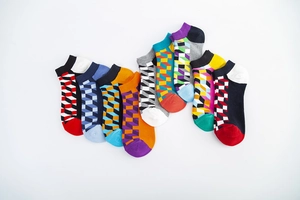Detail view of colorful low-cut socks with 3D geometric cube patterns in nine colorways