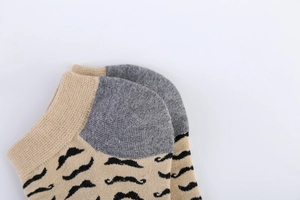Dettaglio di calzini in cotone kaki con stampe a baffi neri e talloni grigi