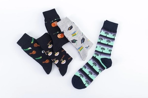 Flat lay of five mid-calf cotton socks with fun food and palm tree patterns on white background