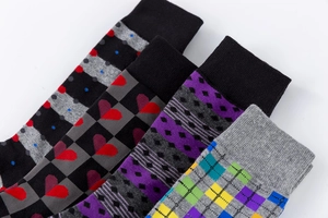 Detail of four men's crew socks featuring colorful geometric, checkered, and plaid patterns