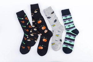 Flat lay detail of five mid-calf cotton socks with unique food and graduation patterns