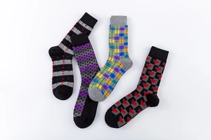 Detail of four pairs of men mid-calf socks with geometric patterns on white background