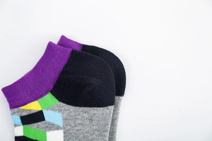 Macro shot of cotton blend socks with colorful geometric patterns and ribbed ankle cuffs