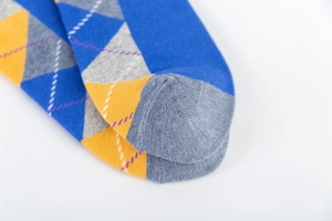 Macro detail of men's argyle socks showing breathable knit texture and grey toe cap