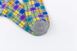 Detailed close-up of gray crew socks with colorful diamond argyle patterns and knit texture