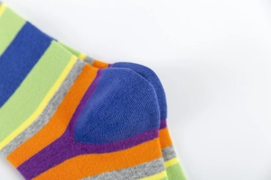 Close-up of colorful striped knitted socks featuring vibrant blue, green and orange bands