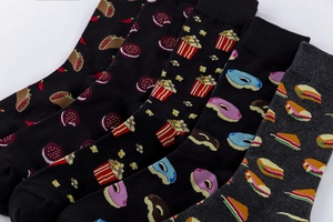 Detail of five pairs cotton socks with vibrant food patterns like tacos and popcorn