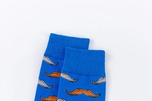 Close-up of royal blue cotton socks with orange and white mustache jacquard knit patterns