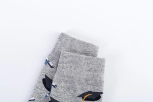 Detailed close-up of grey ribbed cuffs on graduation-themed socks with mortarboard patterns