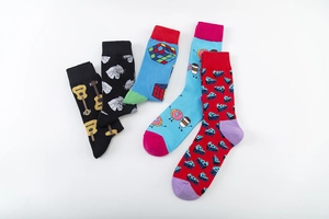 Flat lay detail of five colorful cotton socks featuring guitar, tiger, and cube patterns