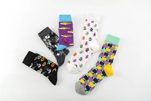 Flat lay of colorful crew socks with diverse patterns including pizza, bears, and camouflage