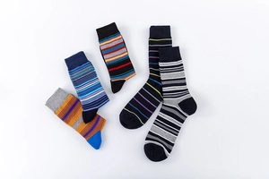 Dettaglio di cinque paia di calze di cotone a righe colorate su uno sfondo bianco puro
