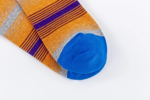 Dettaglio macro delle calze a righe colorate in cotone con punta blu a contrasto
