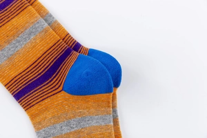 Dettaglio macro di calze in cotone a righe con tallone blu a contrasto e trama a maglia fine