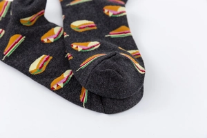 Macro shot of seamless toe stitching and colorful food prints on dark gray cotton socks