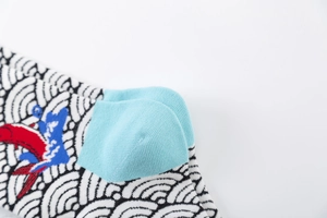 Detail of knitted cotton socks with Japanese wave pattern and koi fish embroidery