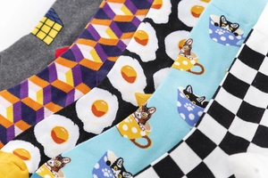 Close-up of assorted cotton crew socks with geometric, fried egg, and cat patterns