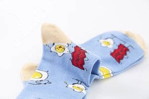 Gros plan détaillé de chaussettes en coton bleu avec motifs œuf au plat et bacon