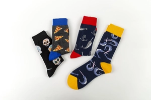 Detail view of colorful mid-calf socks with skull and novelty prints on white background