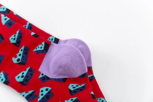 Macro shot showing purple heel stitching and pop art pattern on red cotton socks