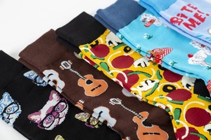 Detail view of colorful knit mid-calf socks with cat, guitar, and pizza patterns