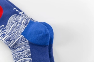 Detail of navy blue cotton socks with red sun and white wave pattern jacquard knitting
