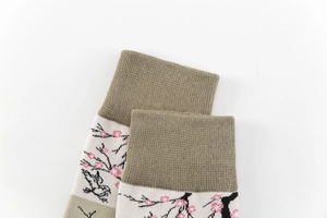 Detailed close-up of ribbed cuffs and pink cherry blossom prints on beige cotton socks