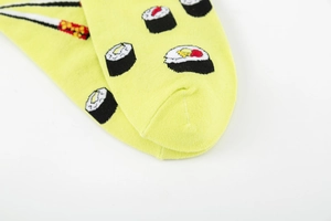 Detail of bright yellow cotton crew socks featuring colorful sushi roll and chopsticks pattern