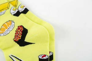 Detailed view of yellow cotton crew socks featuring colorful Japanese sushi patterns