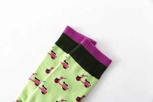 Close-up of green knit socks featuring pink retro scooter patterns and colorful cuffs