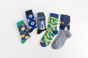 Flat lay of colorful crew socks with pineapple, soccer, UFO, and rocket patterns