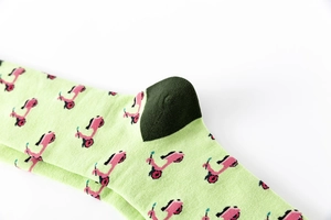 Detailed close-up of light green socks with pink scooter patterns and dark green heel accents