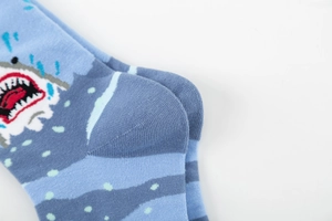 Detail view of light blue cotton socks with shark pattern and wave stripes