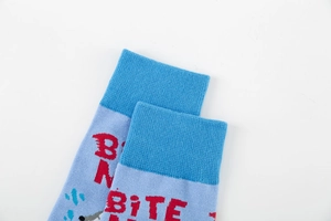 Close-up of blue cotton mid-calf socks featuring a red Bite Me shark knit design