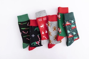Flat lay of 6 pairs of Christmas crew socks featuring Santa, reindeer, and tree patterns