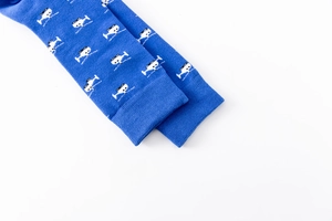 Detail of dark blue crew sock with black and white helicopter prints on cotton knit fabric