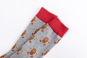 Detailed close-up of grey knit socks with festive gingerbread man patterns and red cuffs