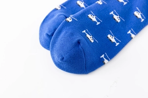 Detailed close-up of dark blue cotton sock with pixel helicopter pattern and smooth seam