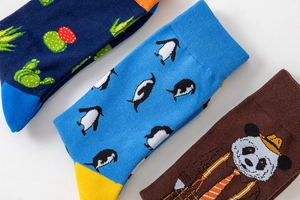 Detail shot of crew socks featuring cactus, penguin, and panda patterns in vibrant colors