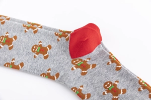 Macro shot of knitted cotton fabric showing festive gingerbread man pattern and red heel