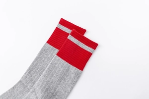 Detail of grey athletic crew socks with ribbed red cuffs and precise knit texture