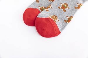 Detail of grey cotton socks featuring red toe accents and cute gingerbread man patterns