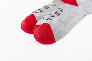 Close-up of gray cotton socks with red toe and IF YOU CAN READ THIS BRING ME BEER text