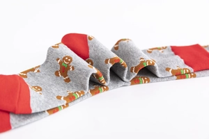 Detail of Christmas gingerbread man pattern and red rib cuffs on grey cotton crew socks