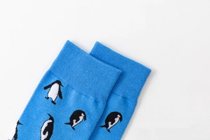 Close-up of ribbed elastic cuffs on sky blue socks with cute penguin patterns