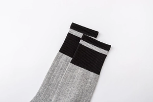 Gros plan détaillé de la chaussette en coton gris clair avec revers côtelé rayé noir