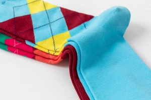 Macro shot of colorful argyle pattern knitted socks in vibrant stacked cotton layers