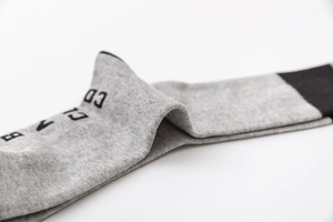 Gros plan sur chaussettes de sport en coton gris avec pointe noire et motifs lettres
