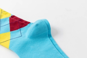 Detail of blue argyle crew sock featuring reinforced heel and premium cotton knit texture